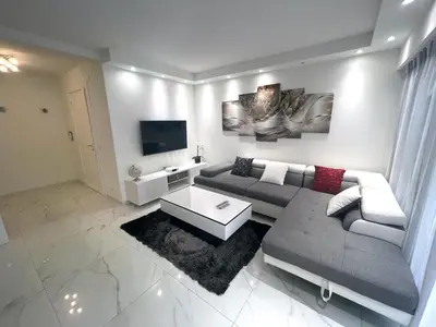 a living room with a couch and a tv at Appartements de Standing Cannes Centre in Cannes