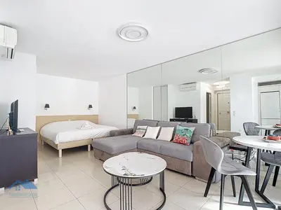 a living room with a couch and a bed at Appartements de Standing Cannes Centre in Cannes