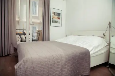 a bedroom with a white bed and a window at AnaZa Appartement in Cannes