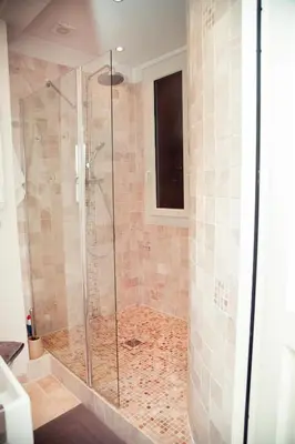 a bathroom with a shower with a glass door at AnaZa Appartement in Cannes