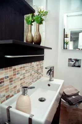 a bathroom with a sink and two vases on a shelf at AnaZa Appartement in Cannes