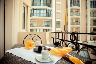 a table with two cups and a cake on a balcony at AnaZa Appartement in Cannes
