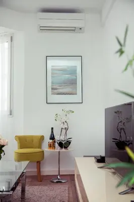 a living room with a yellow chair and a table at AnaZa Appartement in Cannes