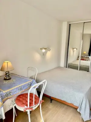 a bedroom with a bed and a chair and a mirror at Idéal congrès Studio 33m2 à 4 minutes du Palais in Cannes