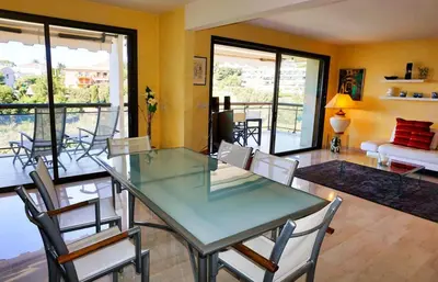 a dining room with a glass table and chairs at Ref BEAUSITE - Palmes d'Or Properties in Cannes