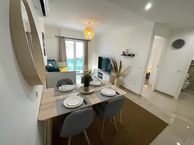 a dining table and chairs in a living room at Cannes Centre, T2 moderne rénové, balcon clim&Wifi in Cannes