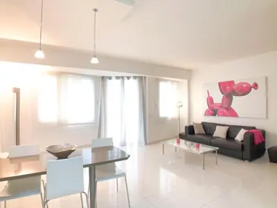 a living room with a black couch and a table at 2 pièces Luxueux en face du Martinez et Croisette in Cannes