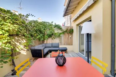 a red table with a vase on it on a patio at C059-Splendid apartment with air conditioned - Cannes in Cannes