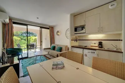 a kitchen and living room with a table and chairs at IMMOGROOM - 2 Rooms - Renovated - Pool - AC - Parking - Garden in Cannes