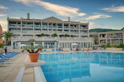 a hotel with a swimming pool in front of a building at IMMOGROOM - 2 Rooms - Renovated - Pool - AC - Parking - Garden in Cannes