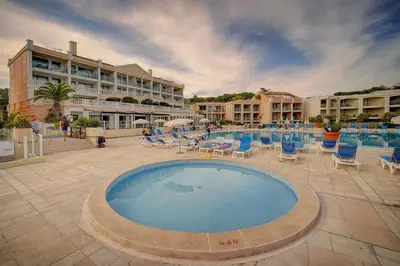 a large swimming pool with chairs and a hotel at IMMOGROOM - 2 Rooms - Renovated - Pool - AC - Parking - Garden in Cannes