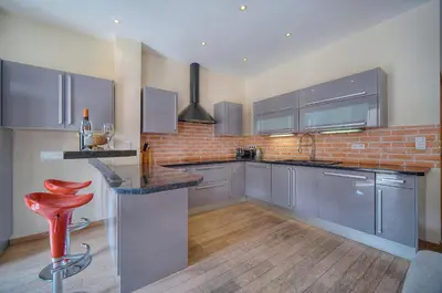 a kitchen with stainless steel appliances and a brick wall at 2 chambres BALCON, FELIX FAURE-COEUR DE CANNES A2B022 in Cannes