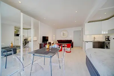 a kitchen and living room with a table and chairs at Lumineux Studio TERRASSE, Rouaze-MARTINEZ CARLTON A0B132 in Cannes