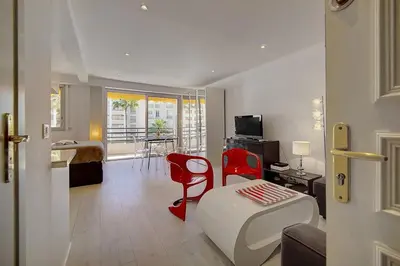 a living room with a bed and red chairs at Lumineux Studio TERRASSE, Rouaze-MARTINEZ CARLTON A0B132 in Cannes