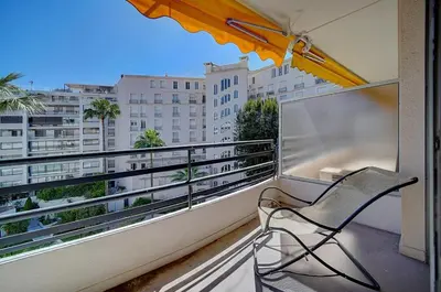 a chair on a balcony with a view of a city at Lumineux Studio TERRASSE, Rouaze-MARTINEZ CARLTON A0B132 in Cannes