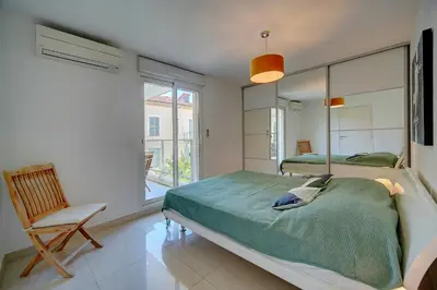 a bedroom with two beds and a chair and a window at Moderne 2 pièces TERRASSE PARKING, Clémenceau A1B230 in Cannes