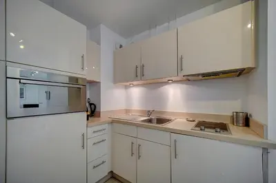 a kitchen with white cabinets and a sink at Moderne 2 pièces TERRASSE PARKING, Clémenceau A1B230 in Cannes