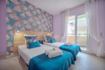 two beds in a room with blue and red wallpaper at Duplex 2 chambres TERRASSE, MEYNADIER- FORVILLE A2B103 in Cannes