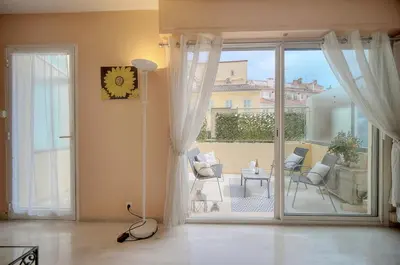 a living room with a sliding glass door to a patio at Duplex 2 chambres TERRASSE, MEYNADIER- FORVILLE A2B103 in Cannes