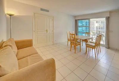 a living room with a couch and a table and chairs at Spacieux 2 chambres TERRASSE, CANNES CENTRE A2B067 in Cannes
