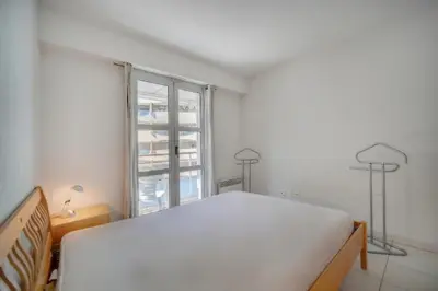 a white bedroom with a bed and a window at Spacieux 2 chambres TERRASSE, CANNES CENTRE A2B067 in Cannes