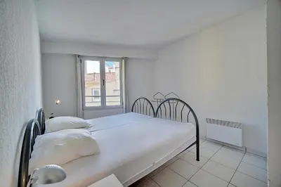 a white bedroom with a bed and a window at Spacieux 2 chambres TERRASSE, CANNES CENTRE A2B067 in Cannes
