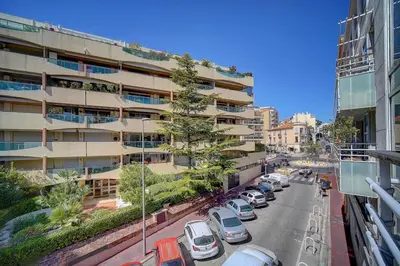 a city street with cars parked in front of a building at Spacieux 2 chambres TERRASSE, CANNES CENTRE A2B067 in Cannes