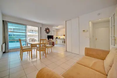 a living room with a couch and a table and chairs at Spacieux 2 chambres TERRASSE, CANNES CENTRE A2B067 in Cannes