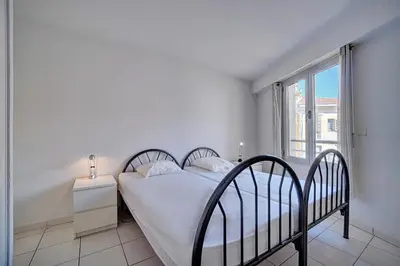 a white bedroom with a bed and a window at Spacieux 2 chambres TERRASSE, CANNES CENTRE A2B067 in Cannes