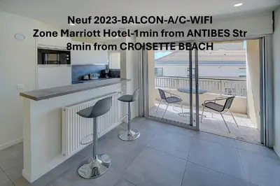 a kitchen with a bar with chairs and a balcony at Cosy Studio BALCON, proche PLAGES- CENTRE CANNES A0B166 in Cannes