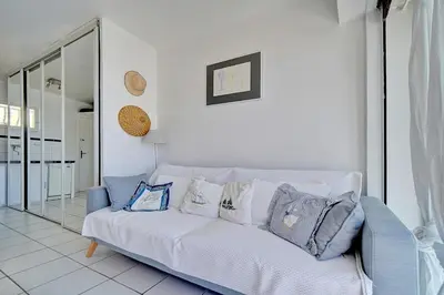 a white couch with pillows on it in a living room at 2 pièces TERRASSE vue MER- 20 m de la PLAGE A1B120 in Cannes