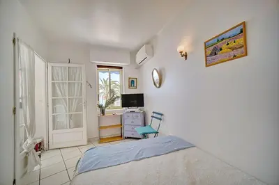 a bedroom with a bed and a desk and a window at 2 pièces TERRASSE vue MER- 20 m de la PLAGE A1B120 in Cannes
