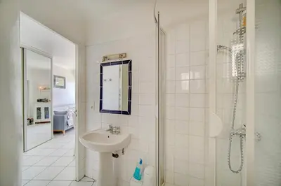 a white bathroom with a sink and a shower at 2 pièces TERRASSE vue MER- 20 m de la PLAGE A1B120 in Cannes