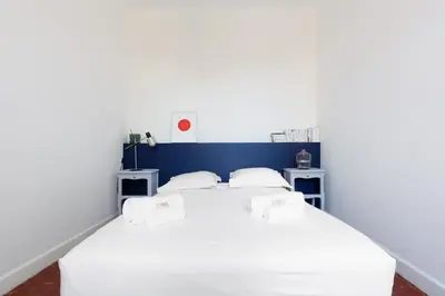 a bedroom with a bed with white sheets and pillows at IMMOGROOM - Bright flat - near shops - CONGRESSBEACHES in Cannes