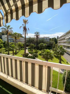 a view from the balcony of a resort with palm trees at Superb Apartment In Cannes With Magnificent View ! in Cannes