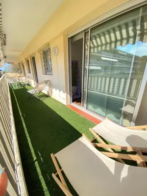 a balcony with chairs and a green lawn at Superb Apartment In Cannes With Magnificent View ! in Cannes