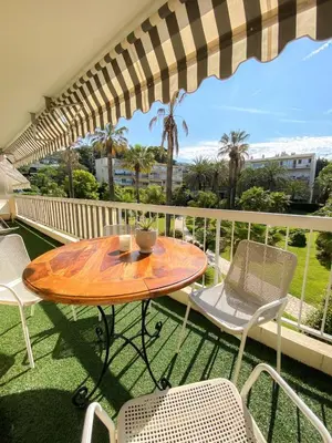 a table and chairs on a balcony with an umbrella at Superb Apartment In Cannes With Magnificent View ! in Cannes