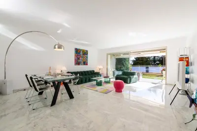 a living room with a table and a couch at 2-Br Luxury Apartment with Sea View and Pool in Cannes
