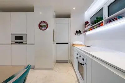 a kitchen with white cabinets and a counter top at 2-Br Luxury Apartment with Sea View and Pool in Cannes