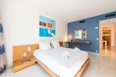 a bedroom with a large white bed with towels on it at 2-Br Luxury Apartment with Sea View and Pool in Cannes