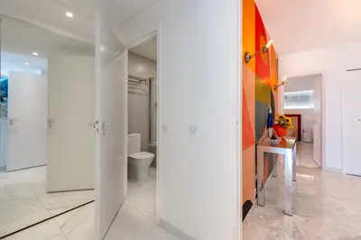 a bathroom with white walls and a toilet in it at 2-Br Luxury Apartment with Sea View and Pool in Cannes