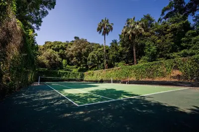 a tennis court with trees in the background at 2-Br Luxury Apartment with Sea View and Pool in Cannes