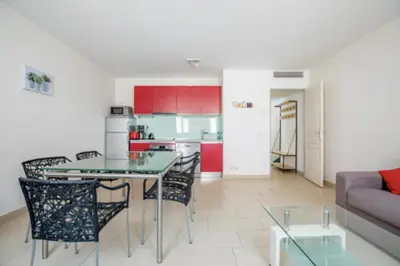 a kitchen and a living room with a table and chairs at Bright Apartment In The Heart Of Cannes in Cannes