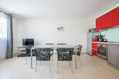 a kitchen with red cabinets and a table and chairs at Bright Apartment In The Heart Of Cannes in Cannes