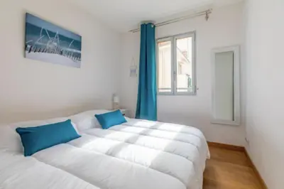 two beds in a room with a window at Bright Apartment In The Heart Of Cannes in Cannes