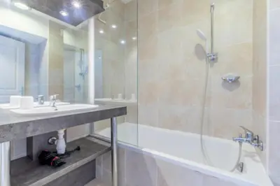 a bathroom with a shower and a tub and a sink at Bright Apartment In The Heart Of Cannes in Cannes
