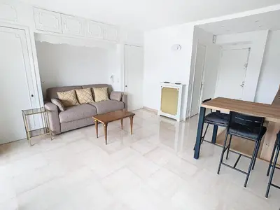 a living room with a couch and a table at Studio luxueux et spacieux avec terrasse in Cannes