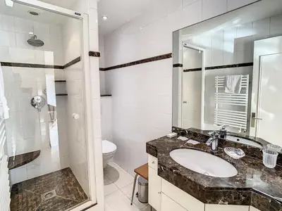 a bathroom with a sink and a toilet and a mirror at Studio luxueux et spacieux avec terrasse in Cannes