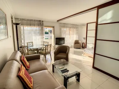 a living room with a couch and a table at Studio luxueux et spacieux avec terrasse in Cannes
