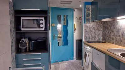 a kitchen with a blue door and a microwave at 3 StarsStudio54 23 Ave Laugier100m Plages Mistral in Cannes